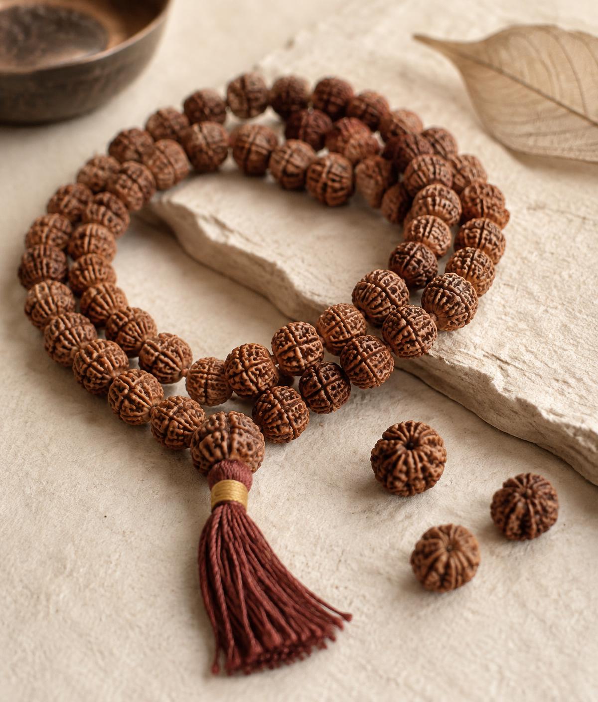 Natural brown Nepali Rudraksha mala and loose beads on ivory handmade paper